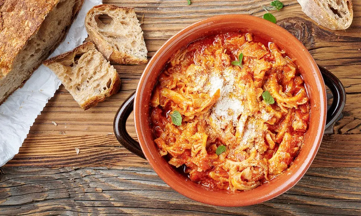Trippa alla romana in terracotta, con pane casereccio e parmigiano. Un classico della cucina romana.
