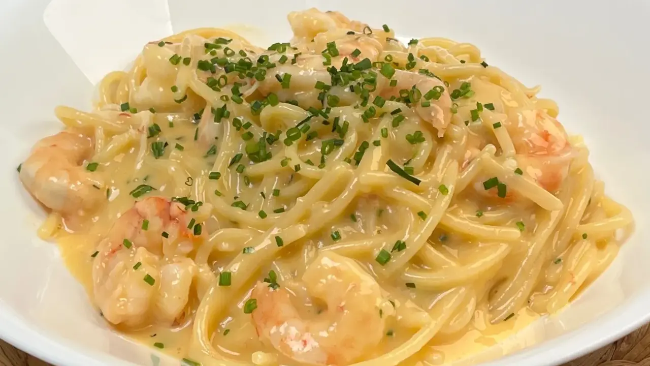 Spaghetti cremosi con gamberi e erba cipollina, una deliziosa carbonara di pesce.