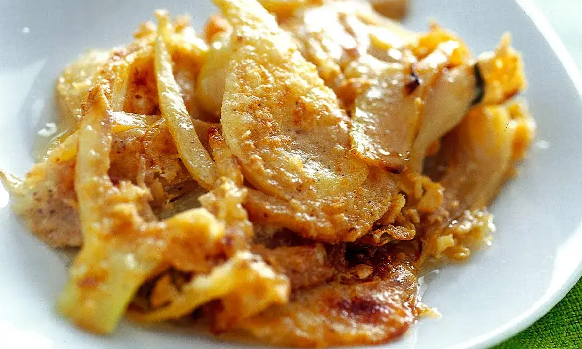 Finoçchi gratinati al forno, un piatto che profuma di casa, servito con un cucchiaio d'argento.