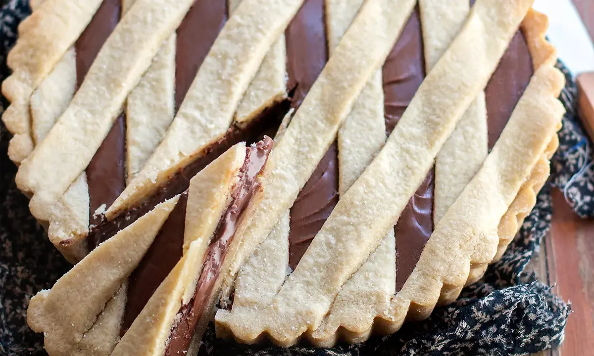 Deliziosa crostata alla Nutella con una griglia di pasta frolla dorata e un ripieno cremoso e invitante.
