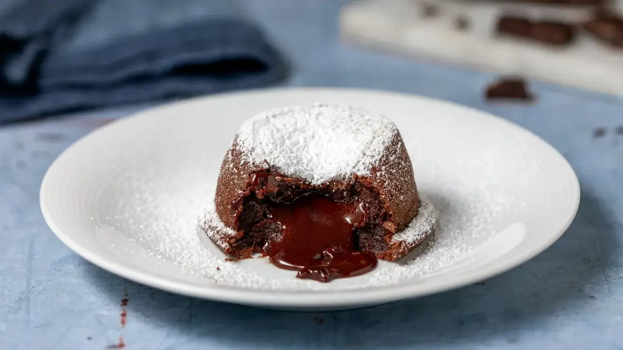 Un tortino al cioccolato con cuore fuso, spolverato di zucchero a velo. Perfetto per dolci morbidi e veloci da preparare.