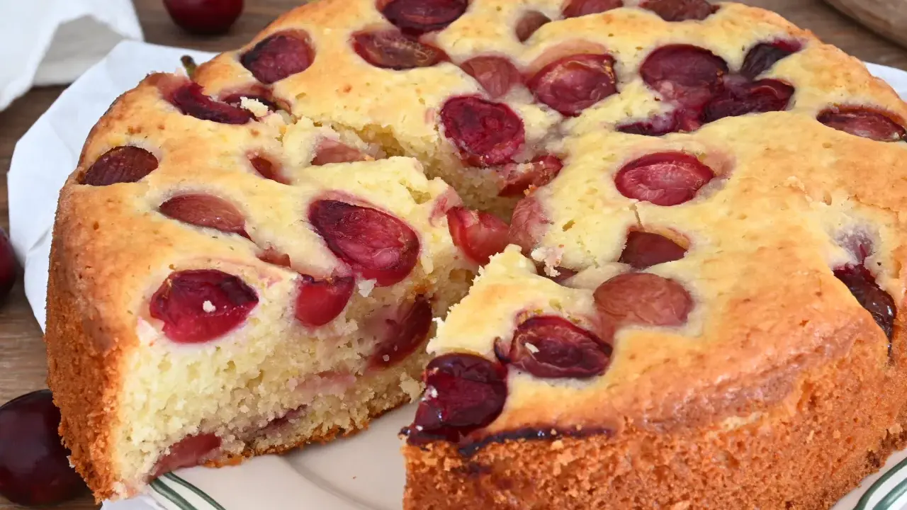 Una deliziosa torta alle ciliegie, con la crosta dorata e tante ciliegie rosse immerse nell'impasto soffice.