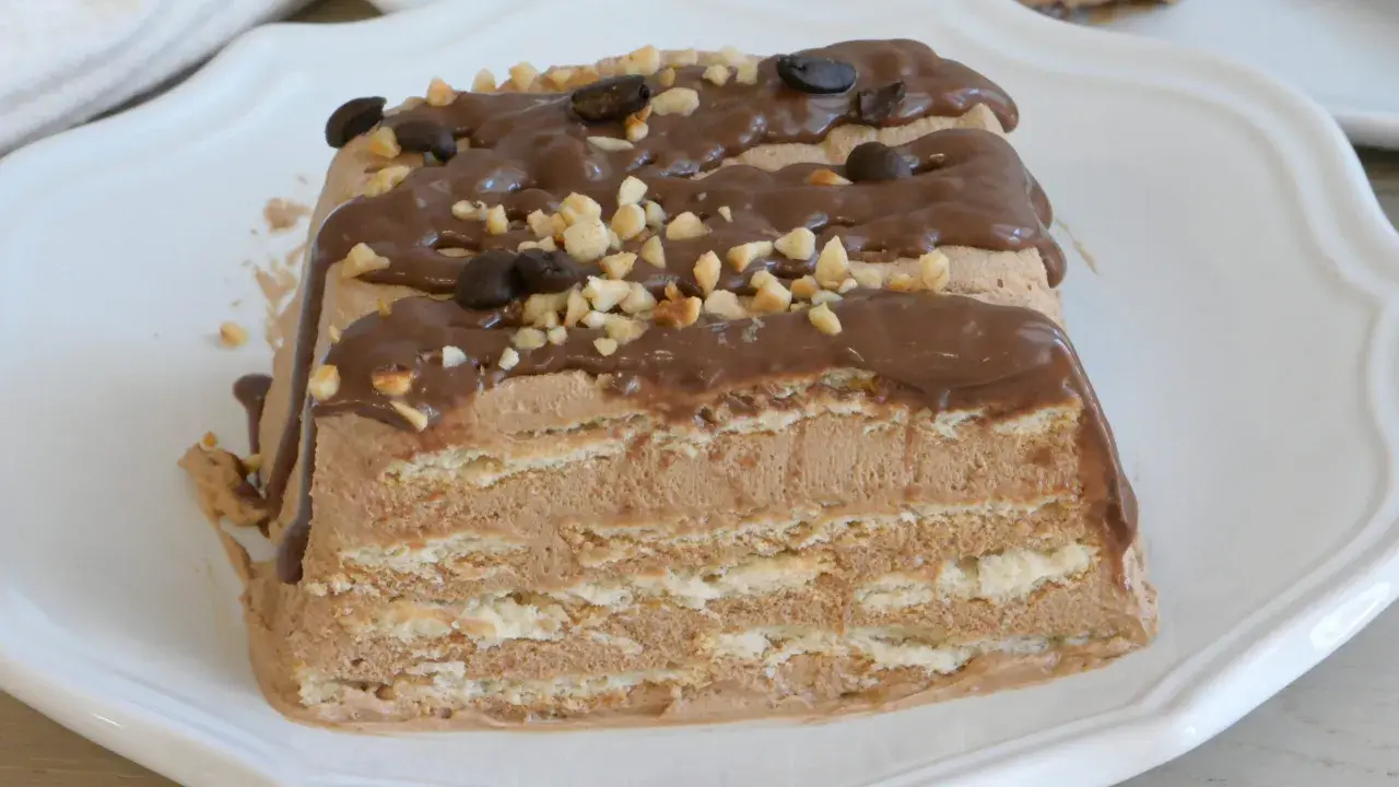 Spumone al caffè a strati, ricoperto di glassa al cioccolato, nocciole tritate e chicchi di caffè.