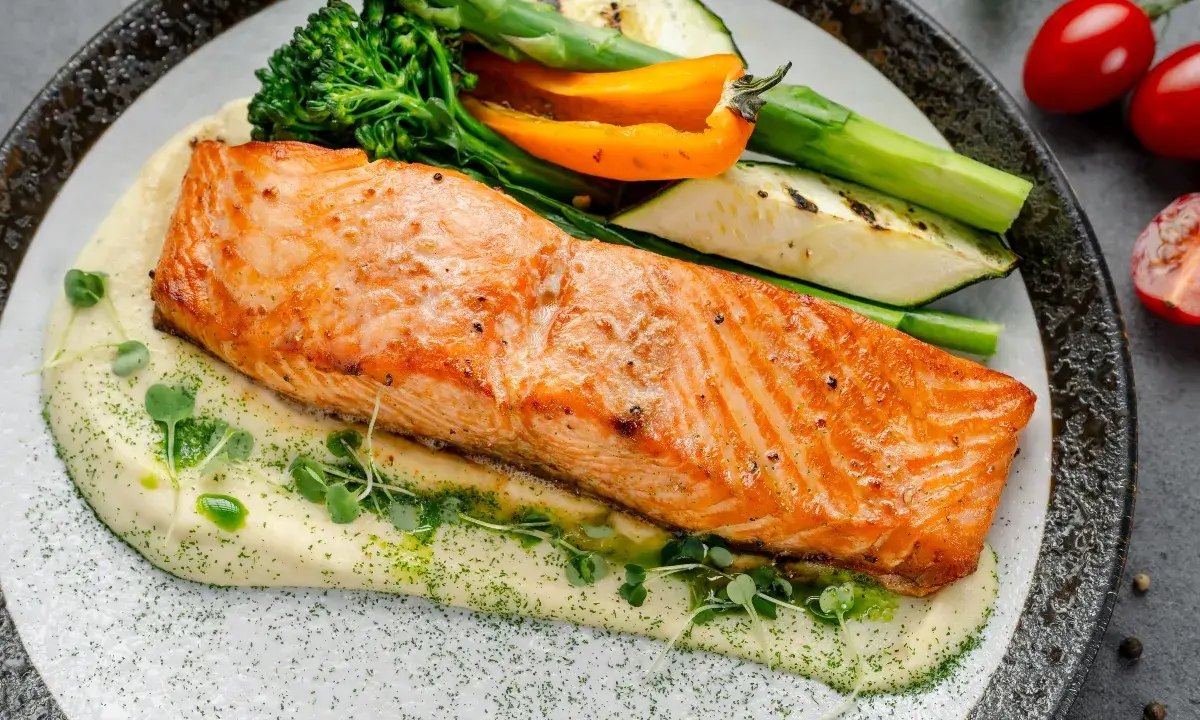 Succulento salmone in friggitrice ad aria su purè cremoso, con verdure grigliate e germogli freschi. Un piatto sano e gustoso.