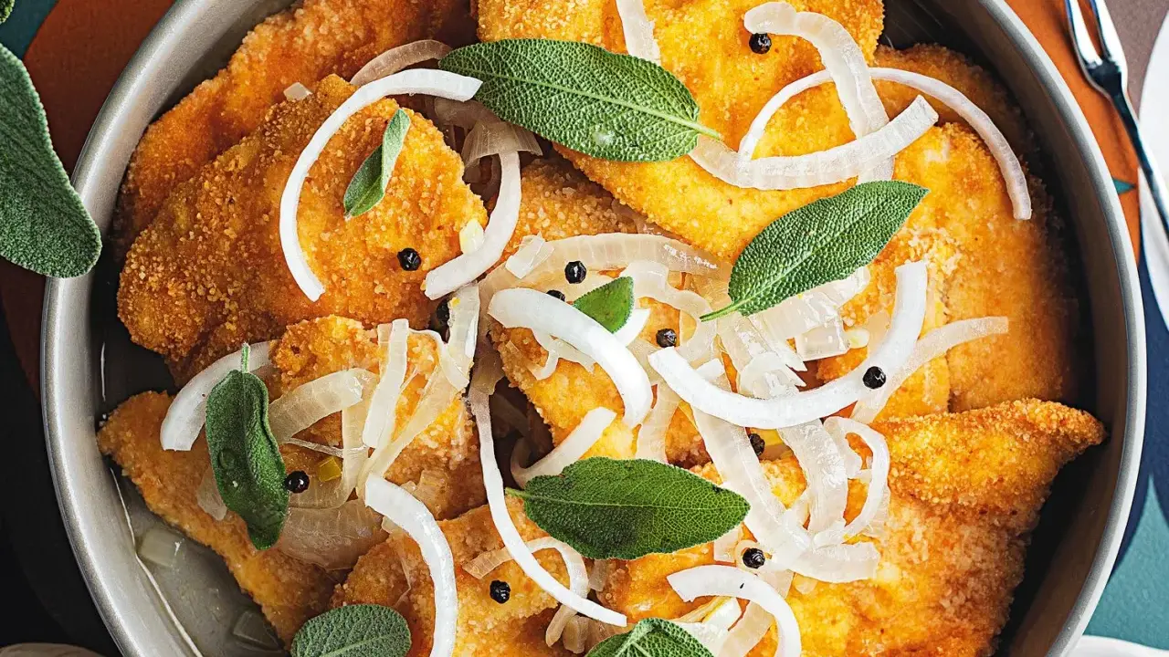 Fette di pollo impanate e dorate, condite con cipolle affettate, pepe nero e foglie di salvia fresca. Un delizioso pollo in carpione.