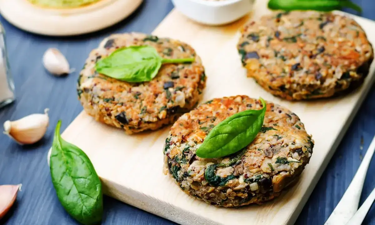 Hamburger di melanzane fatti in casa, guarniti con foglie di spinaci freschi, pronti per essere gustati.
