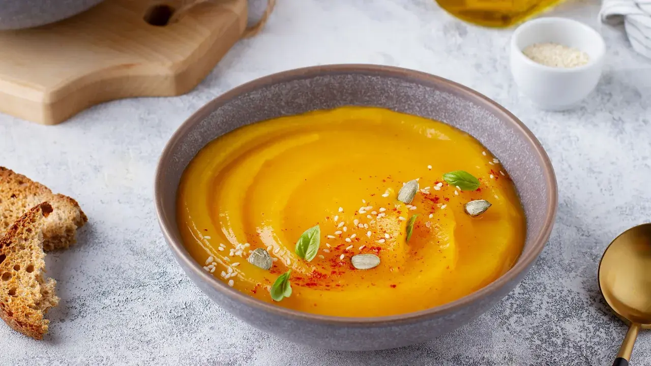 Vellutata di zucca cremosa, guarnita con semi di zucca, sesamo e basilico. Accompagnata da crostini dorati.