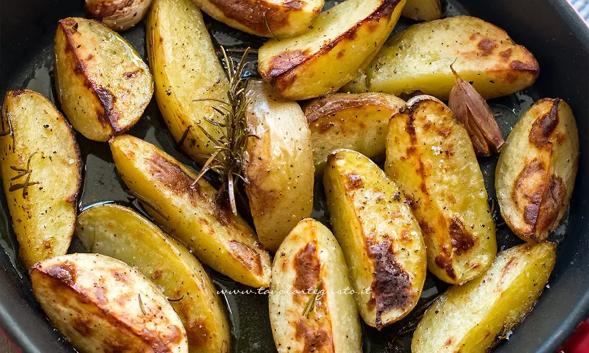 Patate al forno croccanti, dorate e profumate al rosmarino e aglio, pronte per essere gustate.