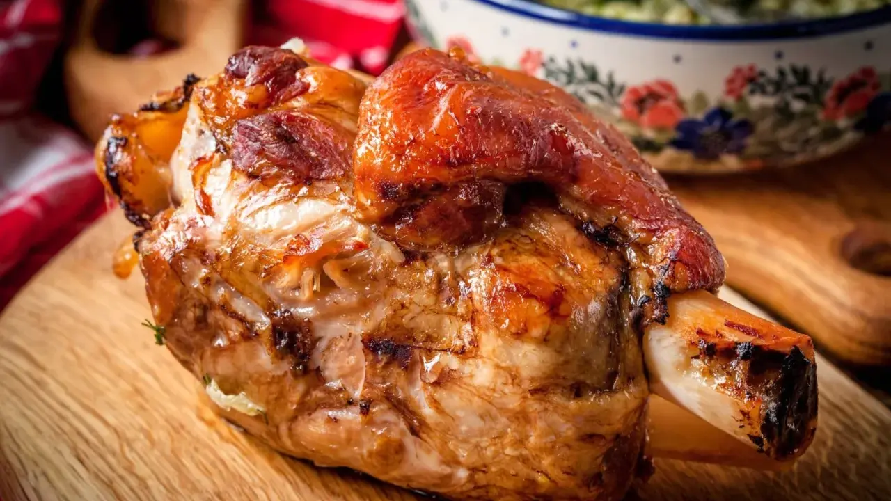 Stinco di maiale al forno, dorato e succulento, pronto per essere gustato.