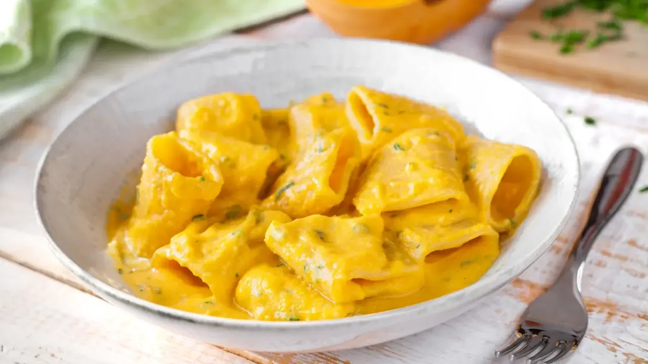 Piatto di pasta e zucca cremoso, con un tocco di erbe aromatiche. Un comfort food autunnale da gustare.