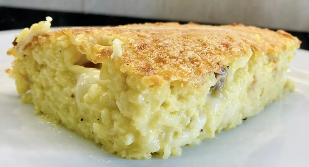 Una fetta di timballo di riso dorato e filante, con un ripieno cremoso e gustoso.