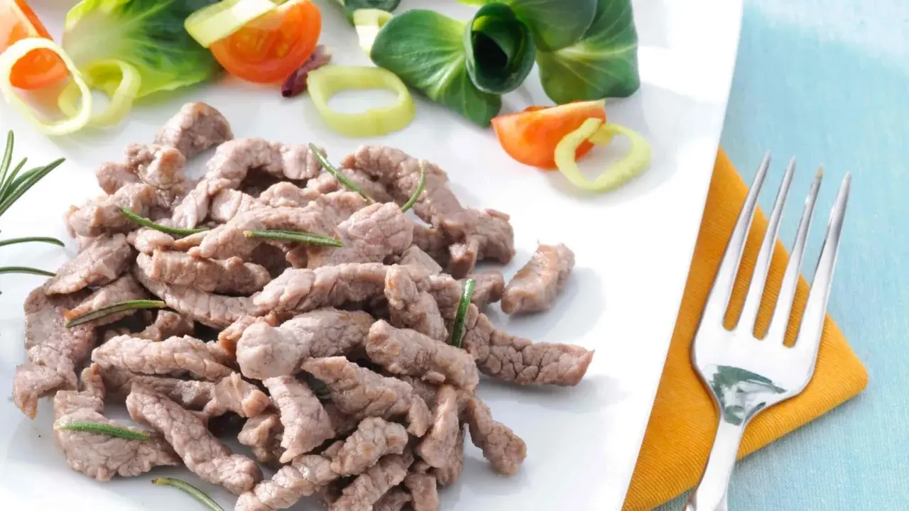 Straccetti di vitello teneri e saporiti, guarniti con rosmarino, accompagnati da un'insalata fresca con pomodorini e cipolla.