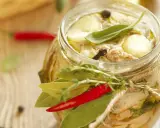 Tonno di coniglio in olio, con erbe aromatiche, peperoncino e spezie, in un barattolo di vetro decorato con spago.