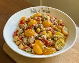 Insalata di tonno con pomodorini gialli, ceci e peperoni rossi, condita con un pesto leggero. Perfetta per un pasto fresco e gustoso.