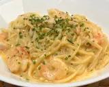 Spaghetti cremosi con gamberi e erba cipollina, una deliziosa carbonara di pesce.