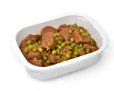 Un saporito spezzatino con piselli in una ciotola bianca, pronto per essere gustato.