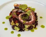 Delizioso polpo alla griglia su letto di riso venere, avocado e pomodorini, condito con salsa verde.