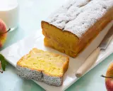 Un delizioso plumcake alle mele, cosparso di zucchero a velo, con una fetta tagliata e mele rosse fresche accanto.