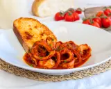 Moscardini in umido succulenti, serviti con pane tostato e pomodorini freschi. Un piatto che sa di mare e tradizione.