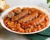 Piatto di salsiccia e fagioli in umido, servito con pane tostato.