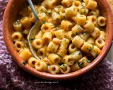 Un piatto fumante di pasta e fagioli, con ditalini e fagioli bianchi in un sugo cremoso, guarnito con prezzemolo tritato.