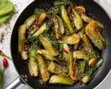 Verdure in padella, bok choy saltato con aglio, peperoncino e semi di sesamo, un piatto saporito e colorato.