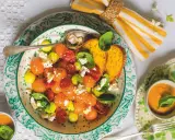 Deliziosa insalata con melone, pomodorini, formaggio e basilico, servita con pane tostato e una ciotolina di gazpacho.