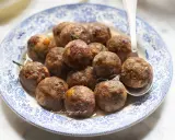 Polpette dorate e succulente in friggitrice ad aria, servite su un piatto decorato.