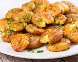 Patate lesse in friggitrice ad aria, croccanti e dorate, condite con erbe aromatiche fresche.