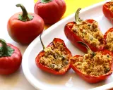 Peperoni ripieni di tonno e pangrattato, dorati e invitanti, su un piatto bianco.
