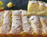 Torta al limone velocissima, soffice e profumata, cosparsa di zucchero a velo e mandorle. Una fetta mostra il ripieno cremoso.