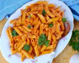 Penne al baffo cremose e saporite, guarnite con prezzemolo fresco, servite su un piatto elegante.