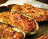 Melanzane ripiene di carne, dorate e gratinate, pronte per essere gustate. Un piatto saporito e invitante.