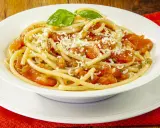 Un piatto di pasta alla carrettiera fumante, con pomodoro fresco, basilico e abbondante formaggio grattugiato.