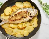Orata in padella con patate e rosmarino, un piatto succulento e profumato, pronto per essere gustato.