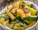 Zucchine in padella, dorate e saporite, con cipolla e pomodoro. Un contorno leggero e gustoso.