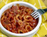 Calamari in umido, un piatto saporito e profumato, servito in una ciotola bianca su un tovagliolo giallo.