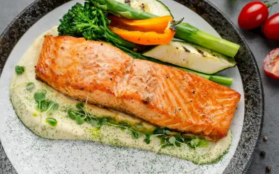Succulento salmone in friggitrice ad aria su purè cremoso, con verdure grigliate e germogli freschi. Un piatto sano e gustoso.