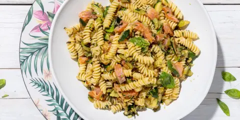 Fusilli con salmone e zucchine, un piatto fresco e colorato, guarnito con basilico.