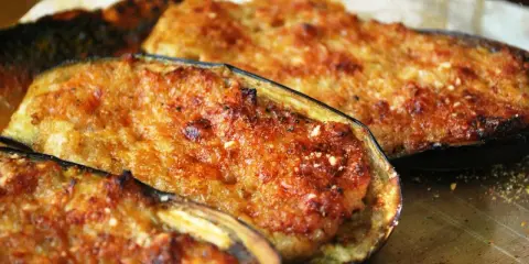 Melanzane ripiene di carne, dorate e gratinate, pronte per essere gustate. Un piatto saporito e invitante.