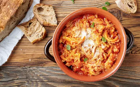 Trippa alla romana in terracotta, con pane casereccio e parmigiano. Un classico della cucina romana.