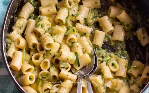 Primo piatto cremoso di pasta con zucchine, condita con un sugo leggero e saporito.