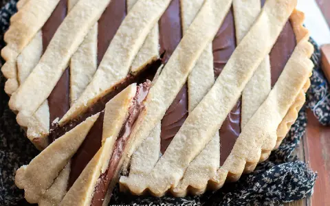 Deliziosa crostata alla Nutella con una griglia di pasta frolla dorata e un ripieno cremoso e invitante.