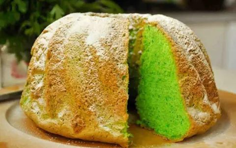 Torta alla menta con un interno verde brillante, cosparsa di zucchero a velo.