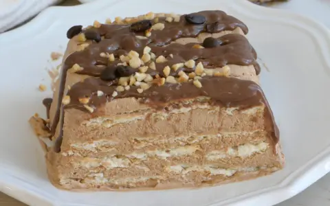 Spumone al caffè a strati, ricoperto di glassa al cioccolato, nocciole tritate e chicchi di caffè.