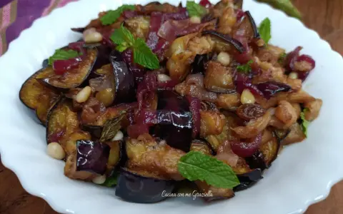 Melanzane in agrodolce, un piatto saporito con cipolle rosse, pinoli e menta fresca. Un'esplosione di gusto!