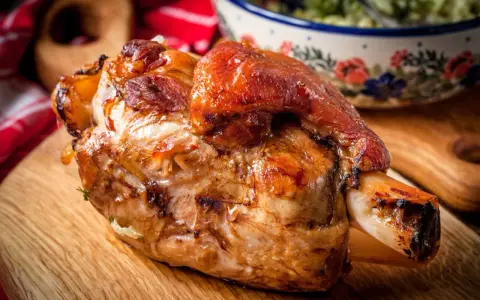 Stinco di maiale al forno, dorato e succulento, pronto per essere gustato.