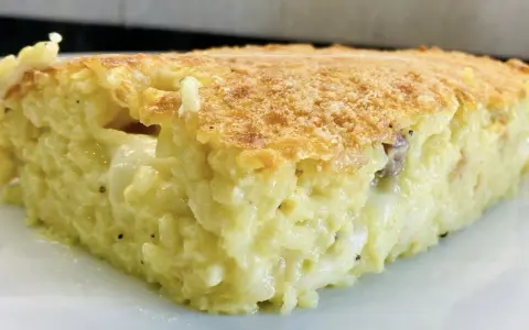 Una fetta di timballo di riso dorato e filante, con un ripieno cremoso e gustoso.