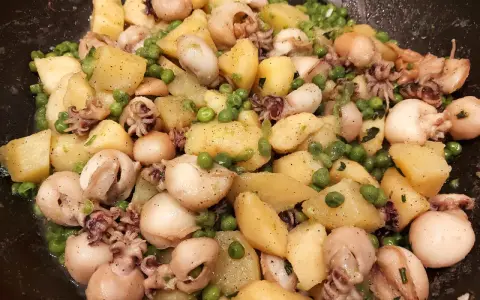 Un gustoso piatto di seppie e patate, con piselli verdi sparsi, condito con erbe aromatiche.