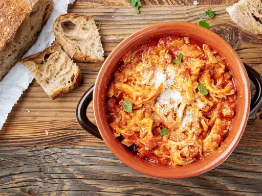 Trippa alla romana in terracotta, con pane casereccio e parmigiano. Un classico della cucina romana.